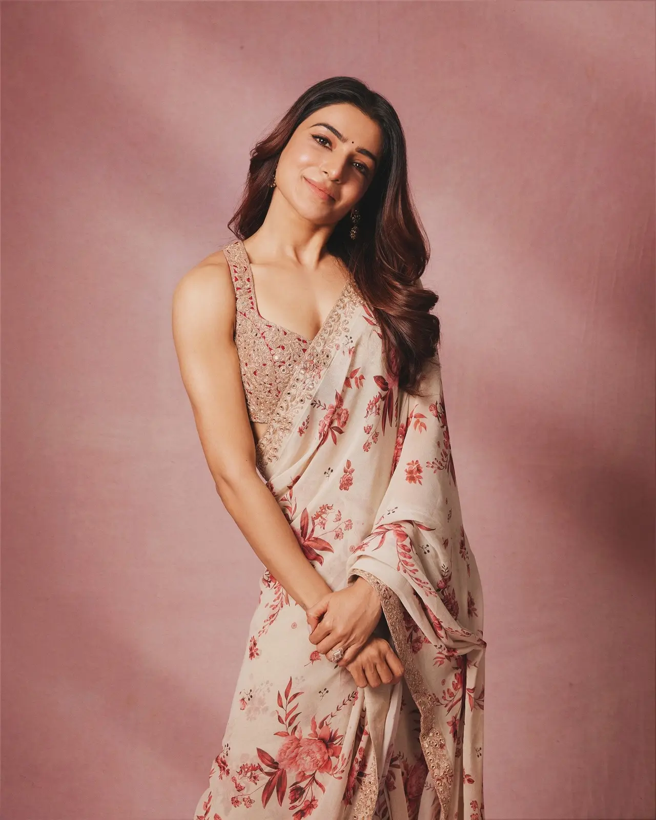 Samantha looks stunning in this breezy, cream-colored saree adorned with vibrant red floral prints and a delicate shimmer border.